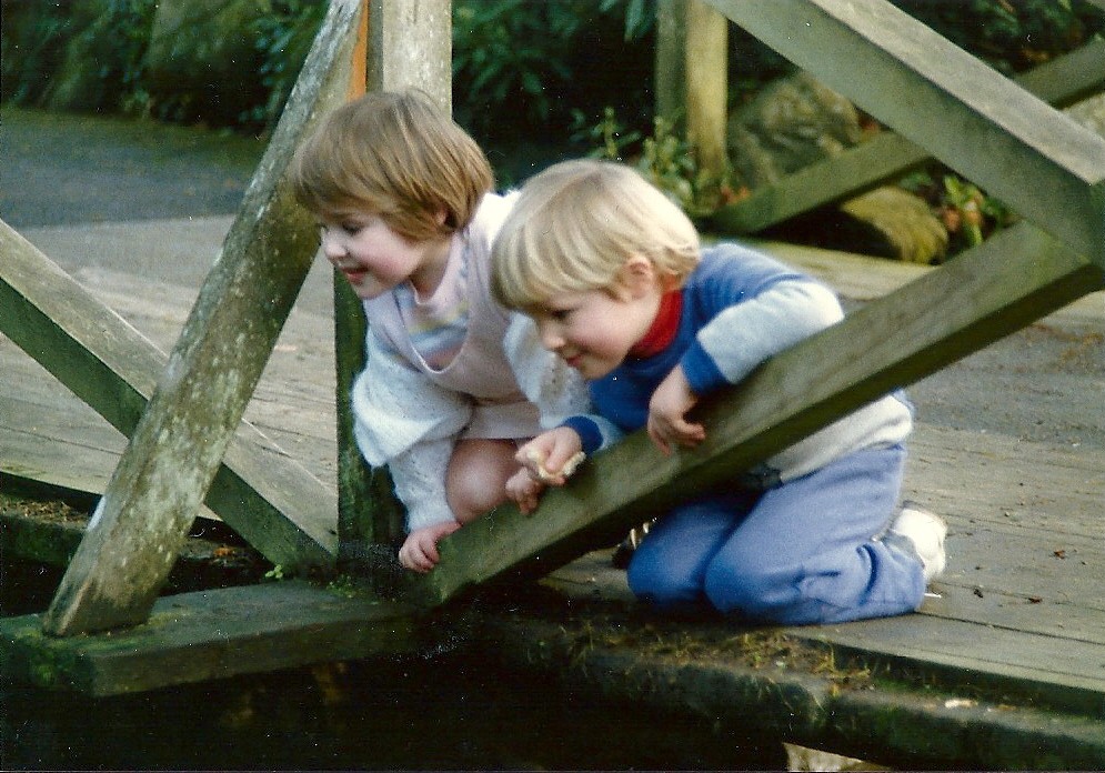 Photo Two children sitting on a bridge